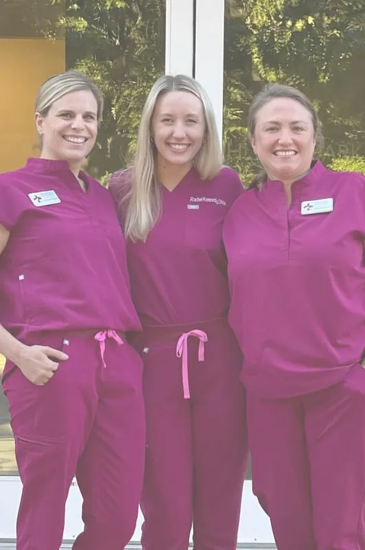 Three Highland Park Animal Hospital team members in scrubs outside the entrance